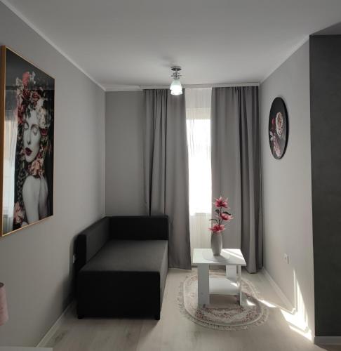 sala de estar con sofá negro y mesa en Flora Apartment en Surčin