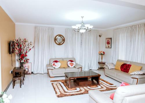 uma sala de estar com dois sofás e uma mesa de centro em Baldwin Beauty House em Accra
