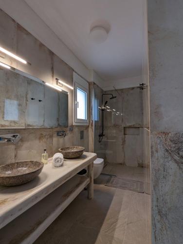 a bathroom with two sinks and a shower at Natura Luxury Suites Parga in Parga