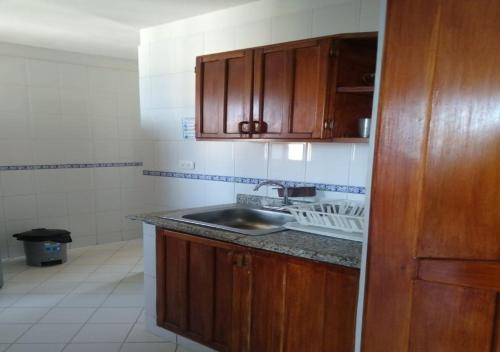 a kitchen with wooden cabinets and a sink at APARTAMENTO EDIFICIO LOS LAURELES in Santa Marta