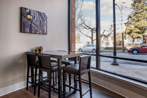 a dining room with a table and chairs and a window at Best Western Plus Philadelphia Airport South - at Widener University in Chester