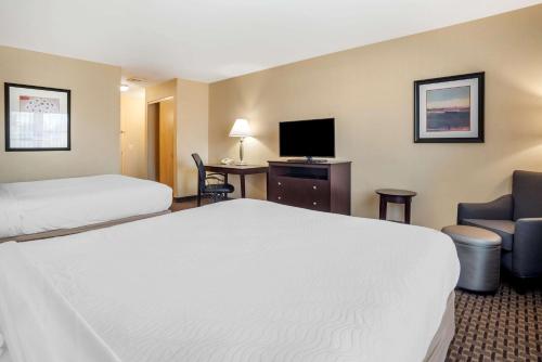 a hotel room with a bed and a desk with a television at Best Western Plus Philadelphia Airport South - at Widener University in Chester