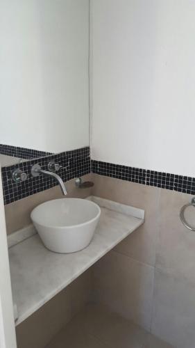 a bathroom with a white sink on a counter at Departamentos Punta Pampa in Las Gaviotas