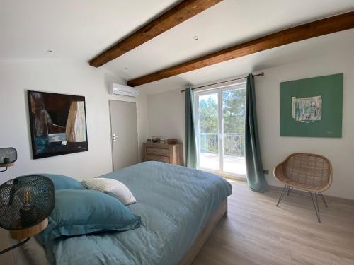 a bedroom with a bed and a window and a chair at La Bastide Blanche Magnifique villa 5 étoiles 5 chambres et piscine privée sur 6500 m VAR in Lorgues