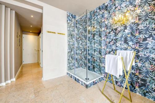 a bathroom with a shower with blue and white tiles at Prestige Suite Sirmione in Sirmione
