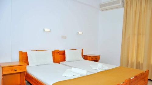 ein Schlafzimmer mit zwei Betten und einem Holztisch in der Unterkunft Villa Maria in Skala Potamias