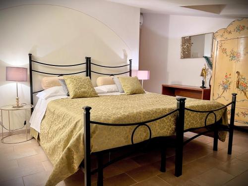 1 dormitorio con 1 cama grande con almohadas de oro en Sui Passi di Francesco, en Valfabbrica
