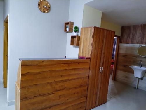 a wooden cabinet in a room with a clock on the wall at The Candy Heights in Rānchī