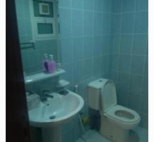 a bathroom with a white toilet and a sink at Lemas 901 in Ajman 
