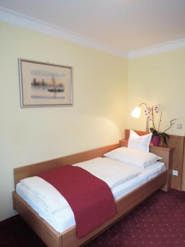 a bedroom with a bed with a red and white blanket at Hotel Binggl in Obertauern