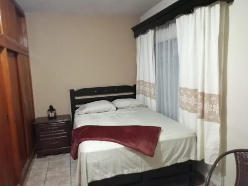 - une chambre avec un lit, une commode et une fenêtre dans l'établissement Casa Mango, à Ciudad Valles