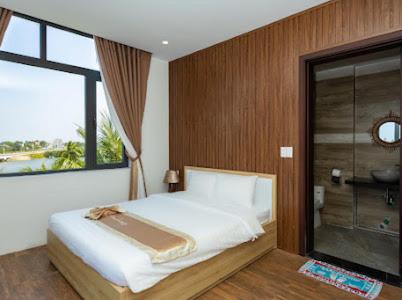 a bedroom with a bed and a large window at Alina Retreat in Hiếu Nhơn