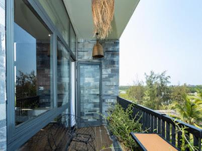 a balcony of a house with a view of the ocean at Alina Retreat in Hiếu Nhơn