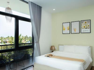 a bedroom with a bed and a large window at Alina Retreat in Hiếu Nhơn