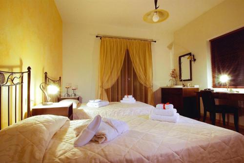 a hotel room with two beds with towels on them at Villa, Choudetsi in Choudetsi