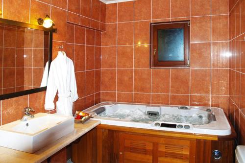ein Badezimmer mit einer Badewanne und einem Waschbecken in der Unterkunft Villa, Choudetsi in Choudetsi