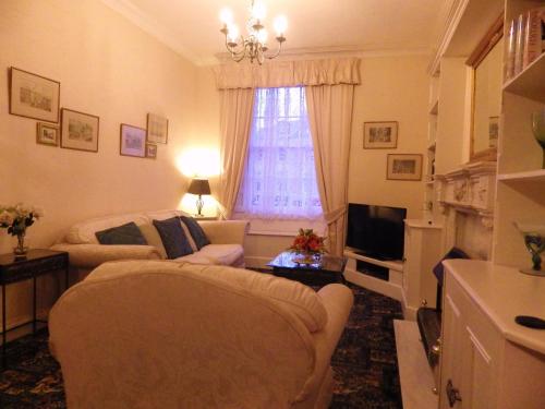 a living room with a couch and a television at The Central Guesthouse in Kelso