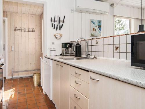 a kitchen with a sink and a microwave at 6 person holiday home in Hemmet in Falen