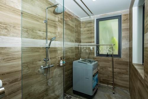 a bathroom with a shower with a glass door at Alina Retreat in Hiếu Nhơn