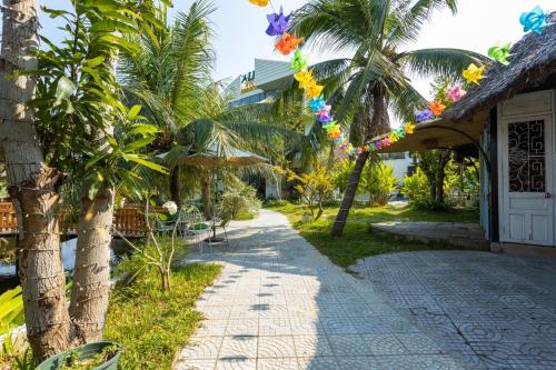 a walkway next to a house with colorful decorations at Alina Retreat in Hiếu Nhơn