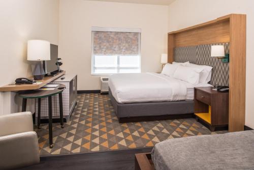 a hotel room with a bed and a desk at Holiday Inn Joplin by IHG in Joplin