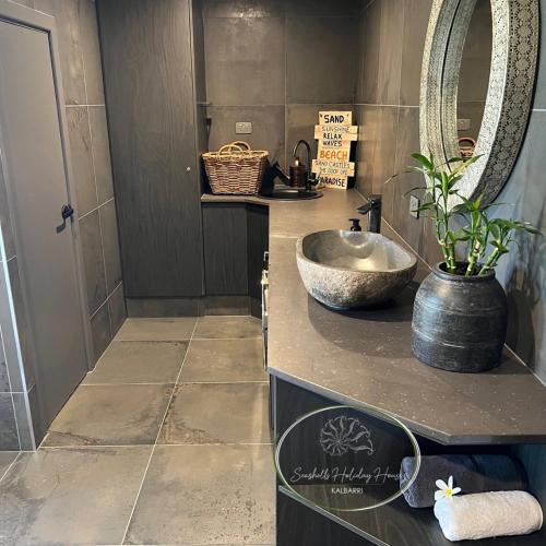 a bathroom with a sink and a mirror at Seashells Holiday House - Kalbarri in Kalbarri