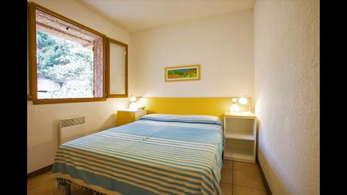 une petite chambre avec un lit et une fenêtre dans l'établissement Air-conditioned apartment near Porto Vecchio, 500 m sea, 6 people, two bathrooms, à Zonza