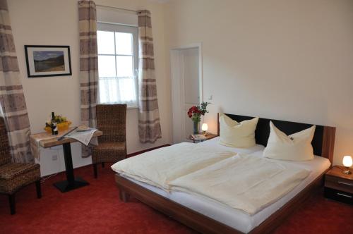 a bedroom with a bed and a table and a window at Nassauer Hof in Sankt Goarshausen