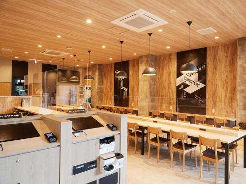 a large kitchen with a long table and chairs at CABIN&HOTEL CONSTANT NAHA in Naha