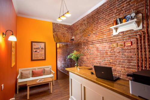 Cette chambre est dotée d'un mur en briques et d'un bureau avec un ordinateur portable. dans l'établissement Post House Rooms, à Lviv