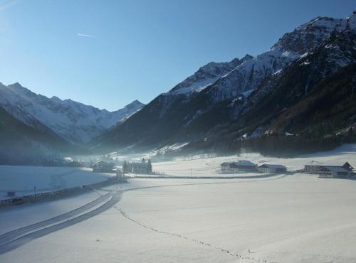 a body of water with mountains in the background at Hotel Kirchdach in Gschnitz