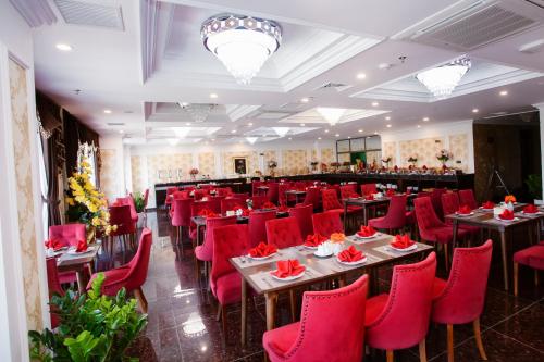 un restaurant avec des chaises et des tables rouges ainsi qu'un bar dans l'établissement Century Hotel Da Nang, à Đà Nẵng