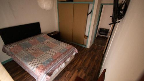 
a bed in a room with a wooden floor at Departamento en Villa Carlos paz in Villa Carlos Paz
