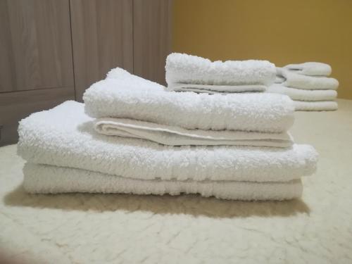 a stack of white towels sitting on a table at Casa tra mare e oliveti in Caprioli