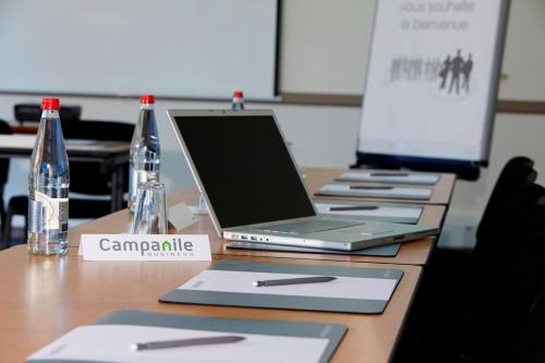 a table with three laptop computers on top of it at Campanile Lille - Lomme in Lomme