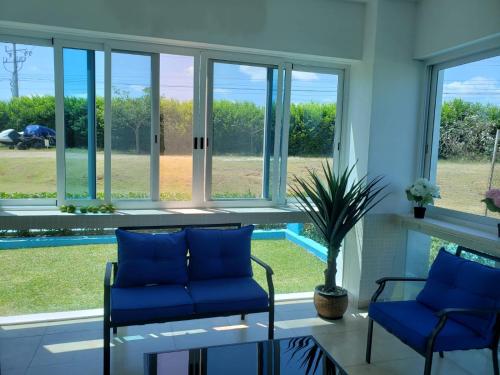 a living room with blue chairs and a glass table at Apartamento en Playa Blanca - PANAMÁ in Río Hato