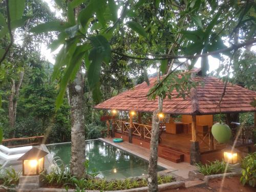 a resort with a pool and a pavilion at Beyond Eco Living in Munnar