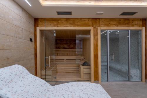 a bedroom with a shower with a glass door at Apartman 65 Zlatibor in Zlatibor