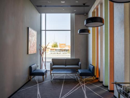 a waiting room with a couch and two chairs at Al Khoory Courtyard Hotel in Dubai