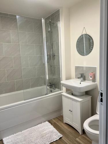 a bathroom with a shower and a sink and a toilet at Cosy double room with private bathroom homestay in Caldecote