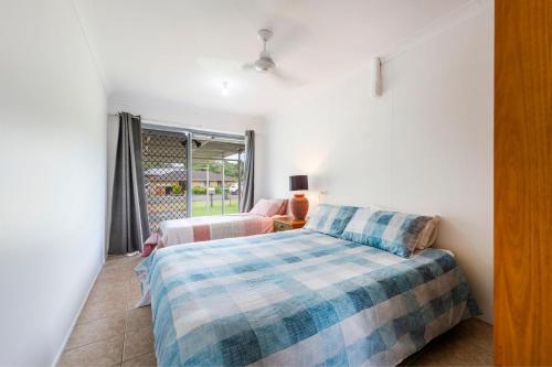 a bedroom with two beds and a window at Compton House in Iluka