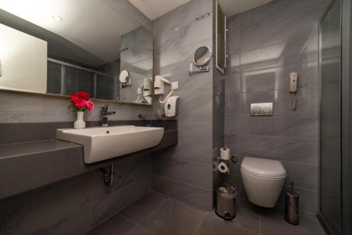 uma casa de banho com um lavatório e um WC em Sunmelia Beach Resort Hotel & Spa-All Inclusive em Kizilagac