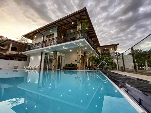 a house with a swimming pool in front of a house at Danisco Leisure Bunglow in Kandy