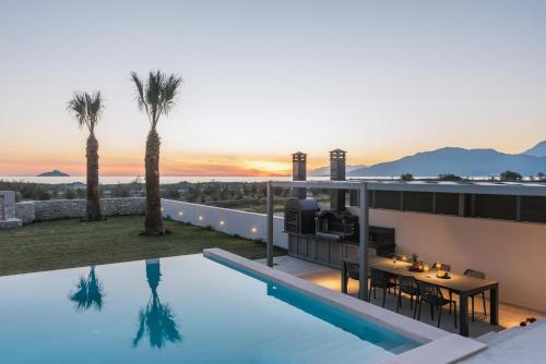 a villa with a swimming pool and palm trees at Grand Sea View Luxury Villa in Kalamaki Heraklion