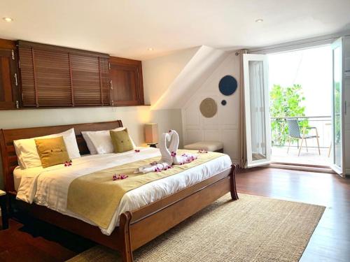 a bedroom with a bed with a stuffed animal on it at Beachfront Villa Charmant With Private Pool in Koh Samui
