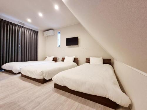una camera con due letti e una tv di PRISM Inn Kamata a Tokyo