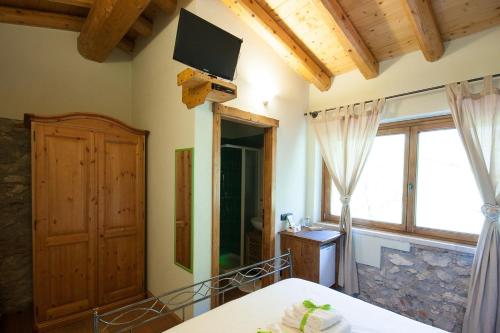 a room with a table and a television on the wall at Agriturismo BioBiò in Vobarno