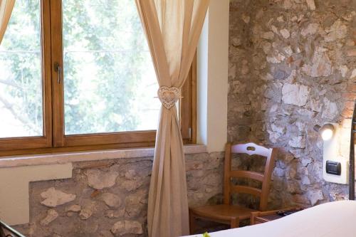 a curtain hanging in a bedroom with a window at Agriturismo BioBiò in Vobarno
