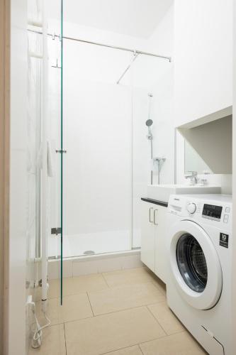 a white laundry room with a washing machine at Luxury Suites Liechtenstein in Vienna