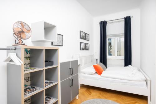a small bedroom with a bed and shelves at Luxury Suites Liechtenstein in Vienna